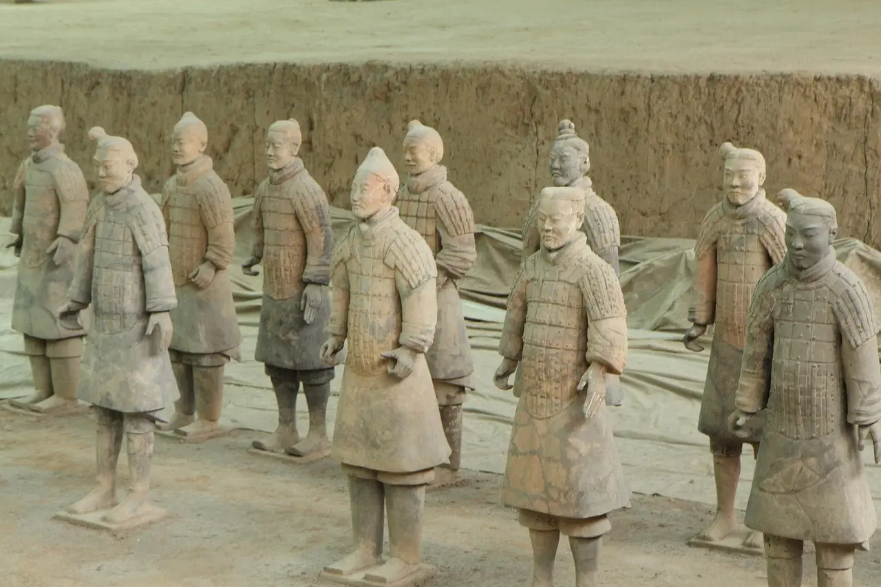 Fileiras intermináveis de guerreiros de terracota em Xi’an, iluminados suavemente dentro do museu arqueológico.