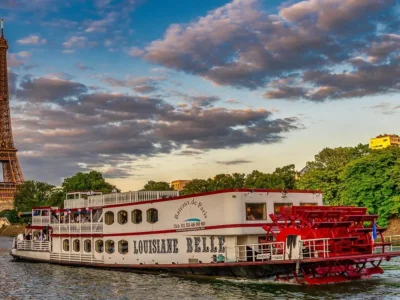 Vista noturna da Torre Eiffel com luzes douradas refletindo no rio Sena