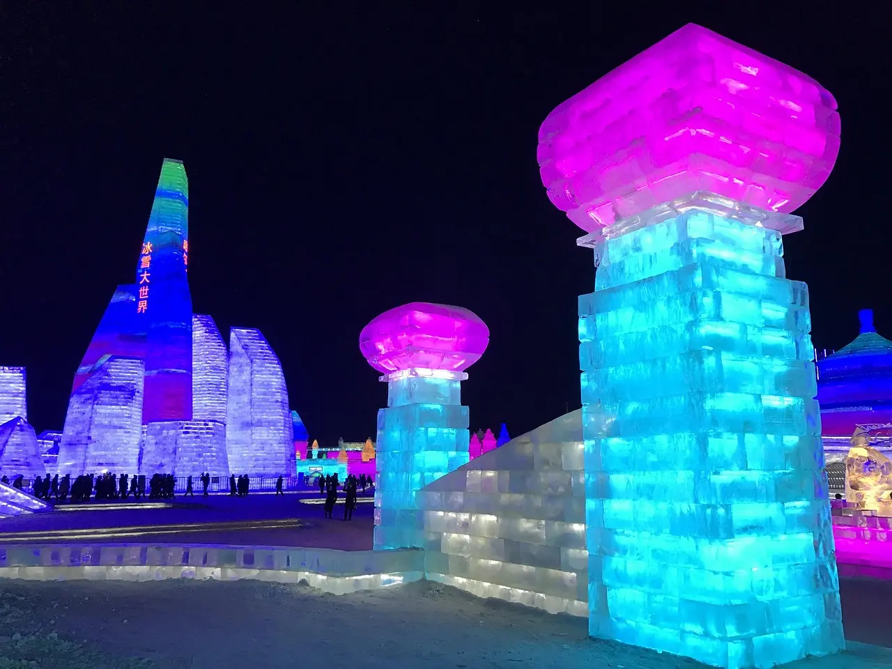 Esculturas de gelo iluminadas no Festival de Gelo de Harbin, com castelos e animais feitos de blocos translúcidos.