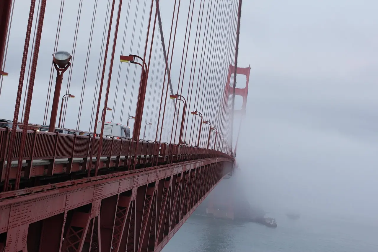 Golden Gate Bridge envolta em névoa matinal com colinas verdes ao fundo