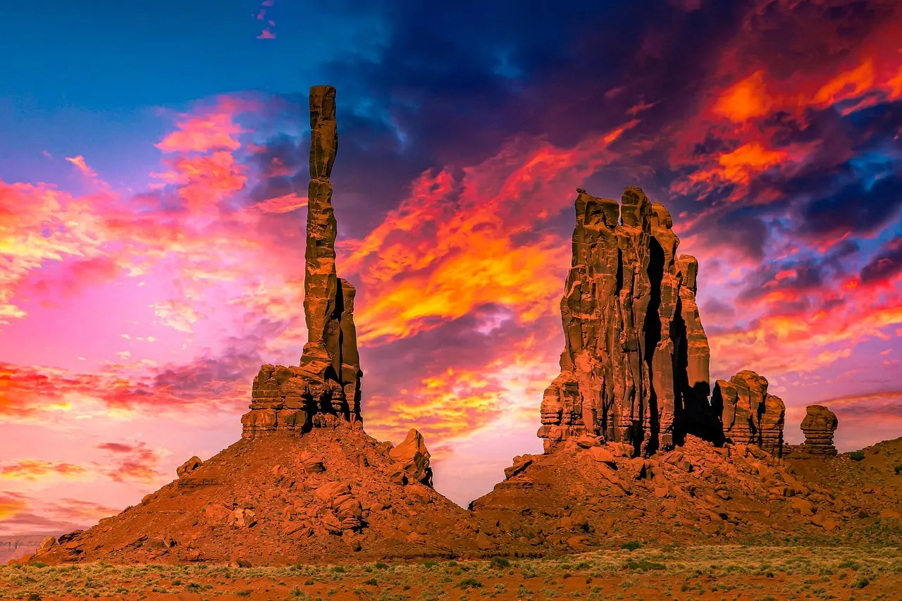 Formações rochosas de Monument Valley ao pôr do sol com silhuetas dramáticas