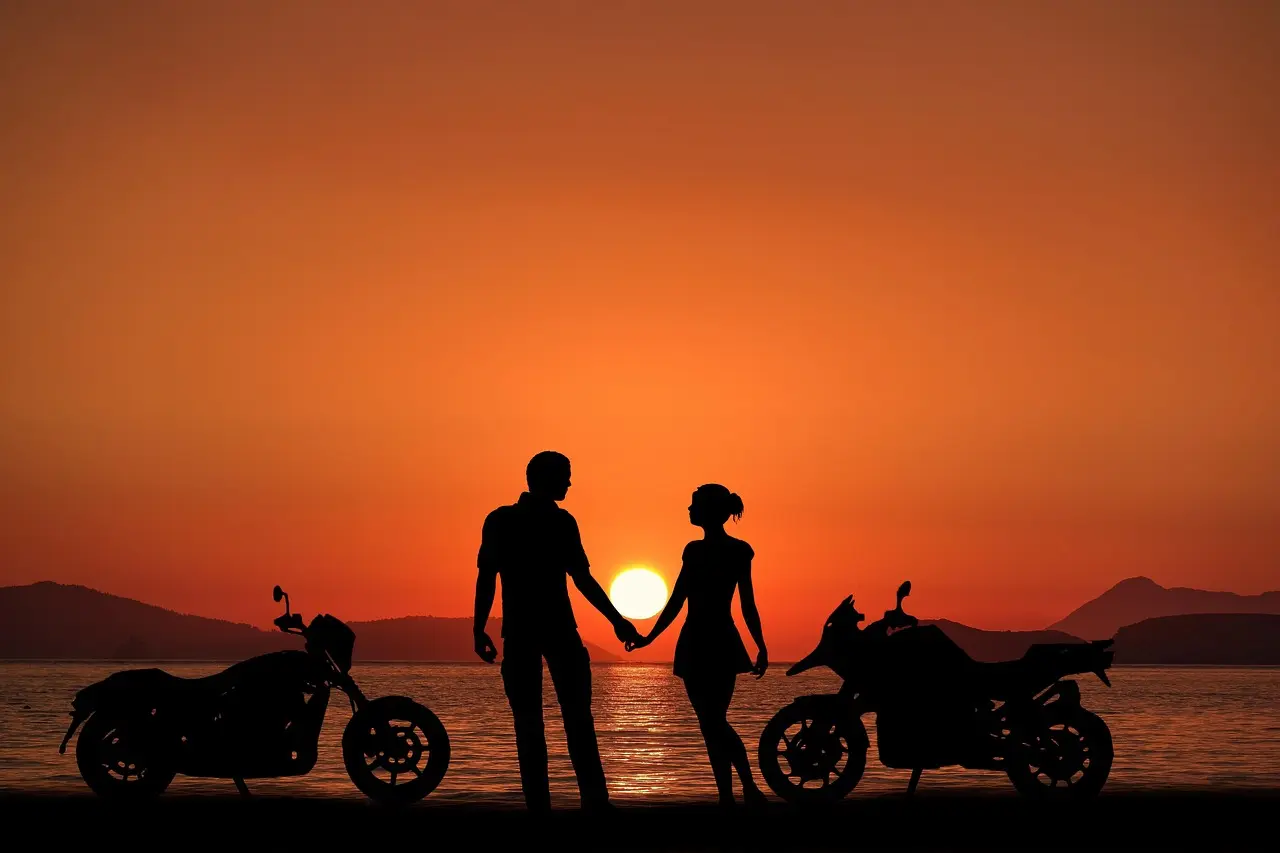 Casal abraçado ao pôr do sol em uma praia deserta, simbolizando o início de uma nova jornada juntos.
