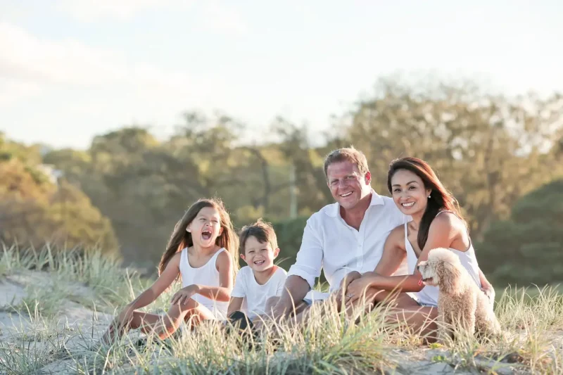 Família brasileira sorrindo em frente a uma paisagem natural no Brasil